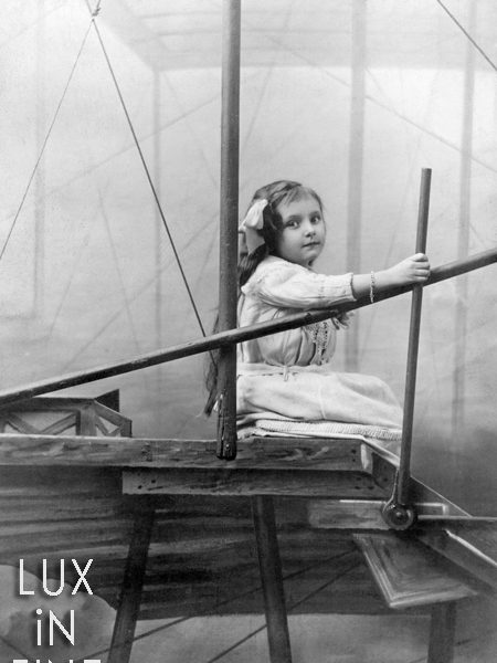 Une petite fille dans un avion factice. Photo prise en studio à Paris en 1910.